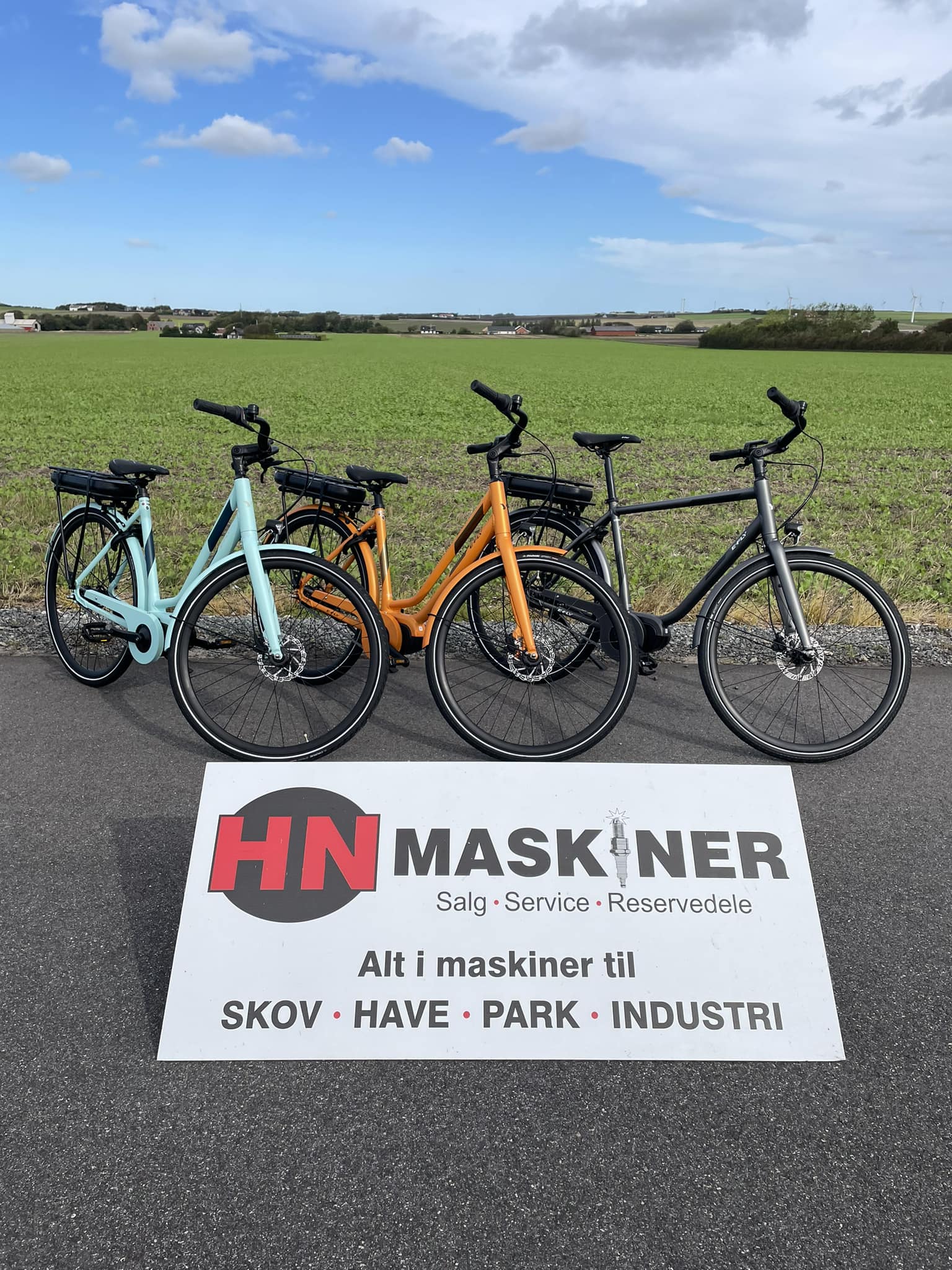 Skilt og cykler med HN Maskiner logo